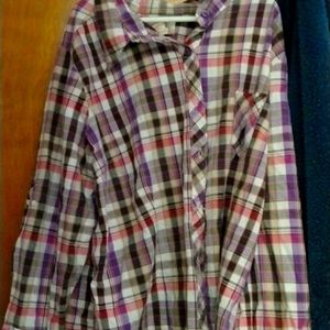 A colorful blouse with buttons  on the front and back with a pocket in the front